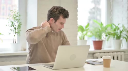 Man Having Neck Pain While Using Laptop in Office