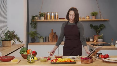 Woman Smiling in Kitchen with Cooking Ingredients
