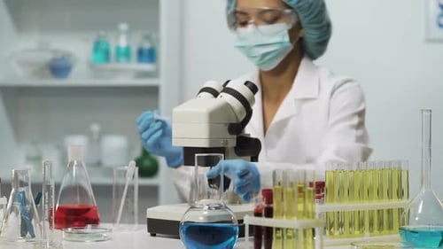 Female Scientist Using Microscope in a Bright Lab