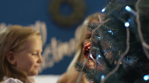 Mother and Daughter Decorate Christmas Tree Together