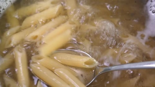 Close Up of Penne Pasta Boiling in Water