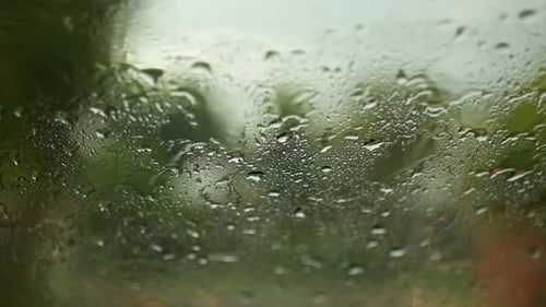 Rain Drops Flow Down Glass Window Close Up
