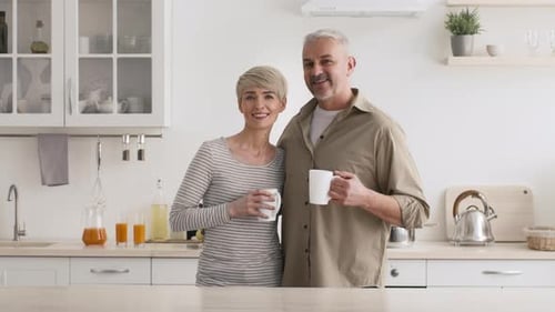 Happy Couple Enjoying Coffee Together in Kitchen