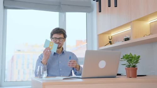Young Adult Presenting Alphabet Flashcards at Desk