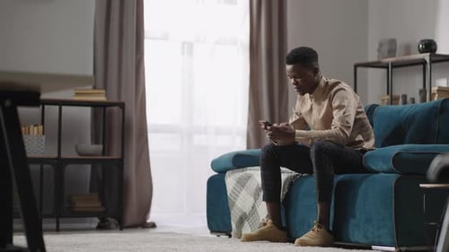 Young Adult Using Mobile Phone on Couch