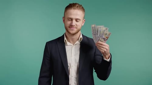 Erstaunt glücklich aufgeregter Geschäftsmann mit Bargeld USD Währung Dollars Banknoten auf Green Wall