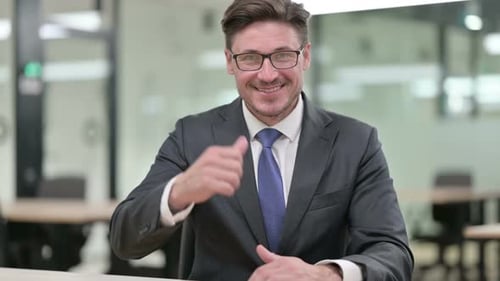 Businessman Gives a Thumbs Up in Office Setting