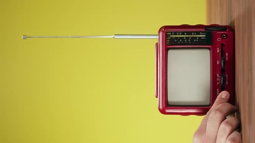 Hand Turns On Vintage Handheld Television