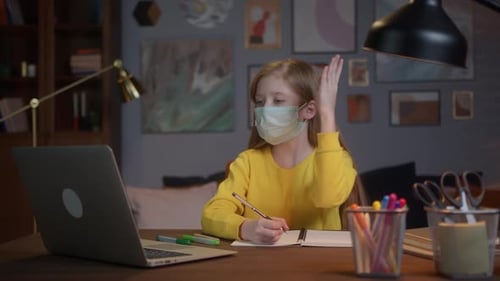 Young Child Learning Remotely at Home Wearing Face Mask