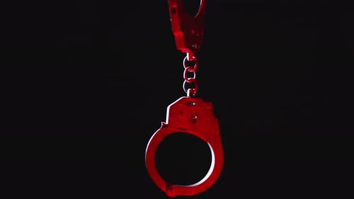 Close Up of Metal Handcuffs with Flashing Lights