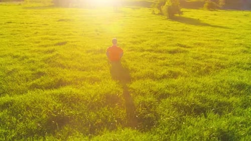 Low Altitude Radial Flight Over Sport Yoga Man at Perfect Green Grass. Sunset in Mountain.