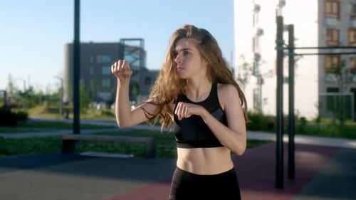 Die schlanke junge Sportlerin trainiert morgens in einer Wohnanlage mit Sport auf der Straße