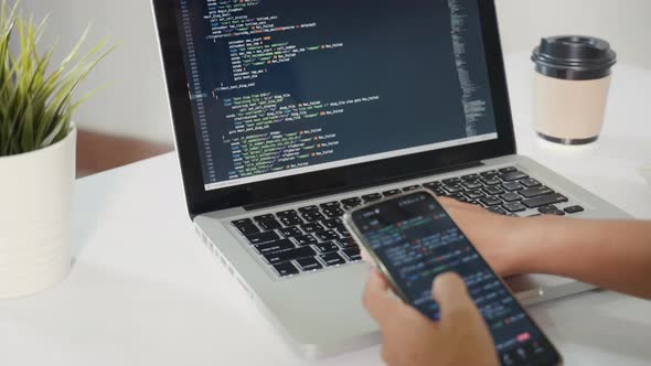 Programmer woman looking mobile phone program code at workplace, People ...