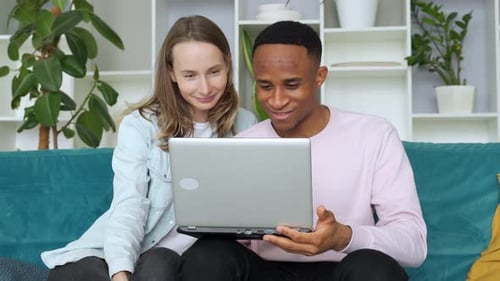 Couple Using Laptop Computer Together on Sofa