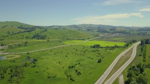 Aerial: Flying Over the Mountainous Terrain and Automobile Route