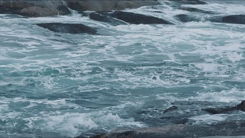 Fascinating View of the Sea Waves Breaking on the Rocky Shore and Whirlpools Between the Stones