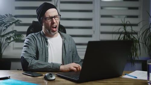 Man Typing on Laptop, Yawning, and Closing Laptop