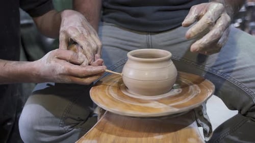 Fabrication d'un pot en argile fait main dans l'atelier. Leçon de poterie avec le maître.