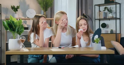 Woman and Daughters Remove Makeup Together at Home
