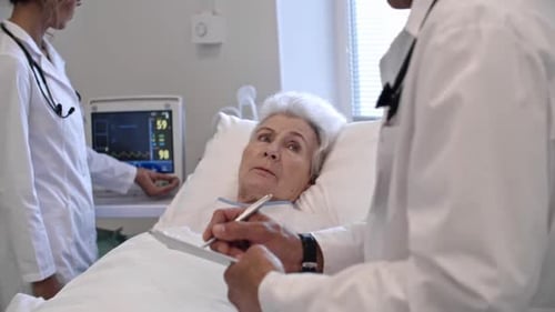 Elderly Patient Talking to Doctor in Hospital Ward