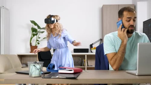 Hermosa mujer rubia explora la realidad virtual mientras su pareja habla por teléfono móvil