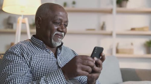 Senior Man Using Smartphone in Living Room