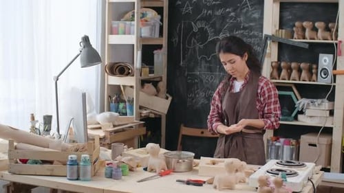 Woman Crafts Small Wood Figures in her Studio