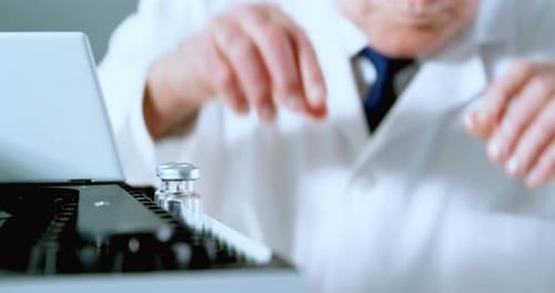 Male scientist placing medical vials on a rack 4k