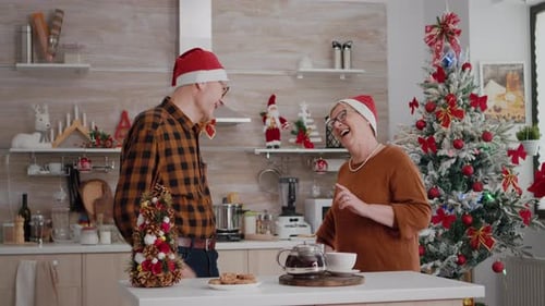 Senior Couple Exchanging Christmas Gifts in Cozy Kitchen