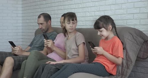Family Using Smartphones Together on a Couch