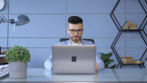 Man Working at Desk on Laptop Computer