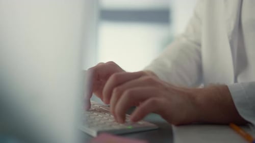 Doctor Hands Using Computer Keyboard in Hospital Close Up