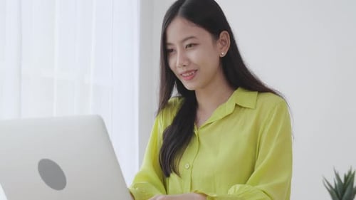 Young asian businesswoman working on laptop computer on desk at home office.