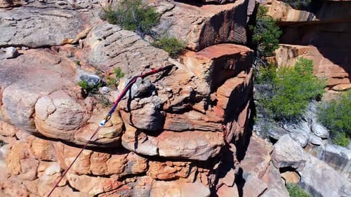 Male highliner walkng on a rope over rocky mountains
