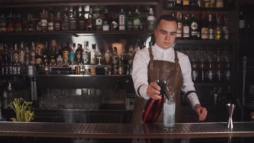 Bartender Adding Soda to Cocktail at Bar