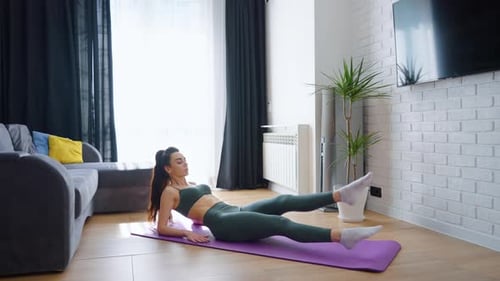 Woman Doing Leg Lifts on Yoga Mat Indoors