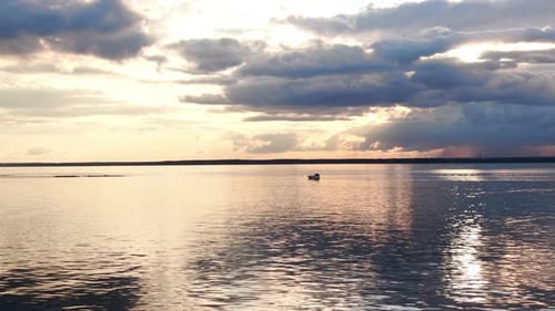Boat Sailing on Calm Waters at Golden Hour