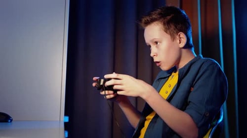 Side view of a boy playing games at home