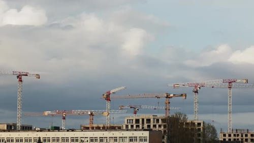 Construction Cranes Above City Buildings