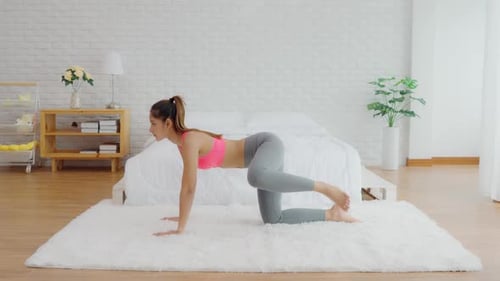 Woman Doing Donkey Kicks Exercise in Bedroom