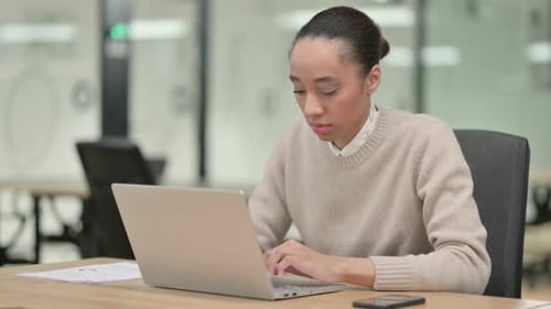 Woman Working on Laptop in Modern Office