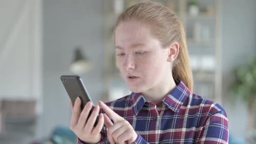Surprised Woman Using Mobile Phone Indoors