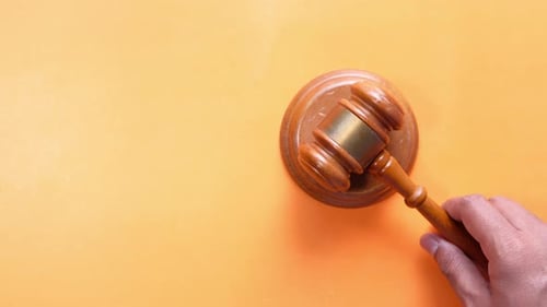 Judge Gavel Tapped Against Orange Background