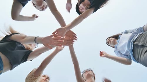 Young Adults Joining Hands in Team Celebration