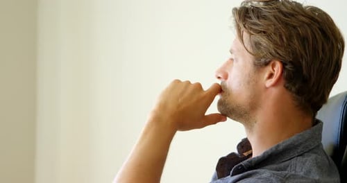 Mann entspannt sich im Wohnzimmer zu Hause 4k