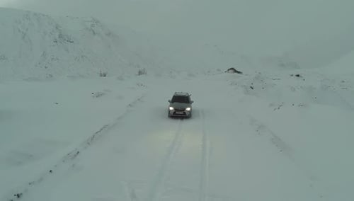 Car on Snow-Covered Road in Mountains, Bird Eye View