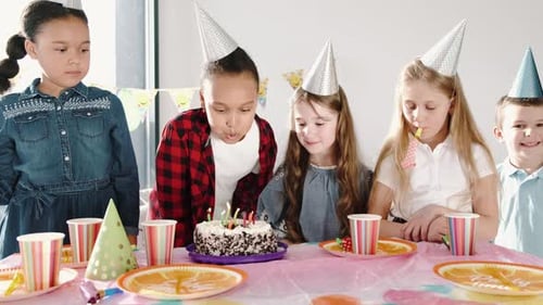 Children Celebrating Birthday Party Blowing Out Candles