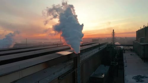 Zone industrielle avec tuyau Une épaisse fumée blanche est déversée du tuyau d'usine contrairement au soleil
