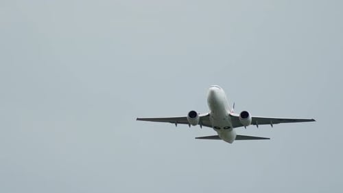 Commercial Airplane Flying in Cloudy Gray Sky