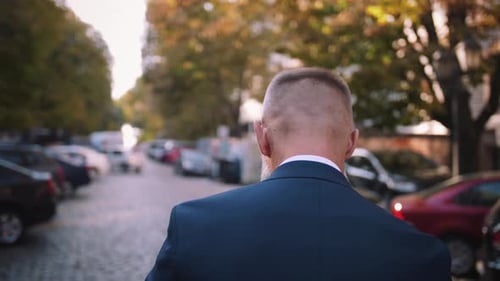 Handsome Bearded Mature Man in Suit Walking Outdoors on Modern Building Background During Sunny Day